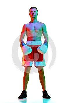 Full-length portrait of sportsman, boxer, mixed martial art fighter workout against white background in mixed neon