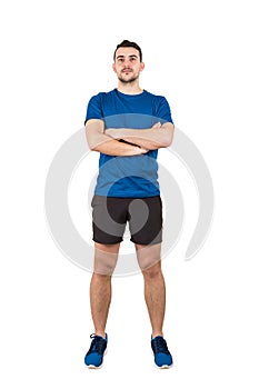 Full length portrait of strong man professional athlete keeps arms crossed, wearing blue t-shirt and black shorts looking