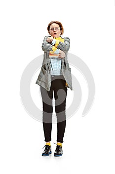 Full length portrait of a surprised female student holding books isolated on white background