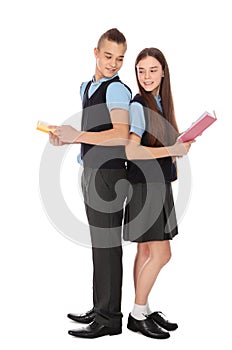 Full length portrait of teenagers in school uniform with books on white