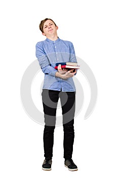Full length portrait of tired student boy carrying two heavy books in his hands isolated over white background. Has to study the