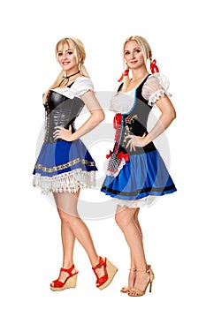 A full length portrait of two beautiful women in a traditional costume isolated on white. Oktoberfest