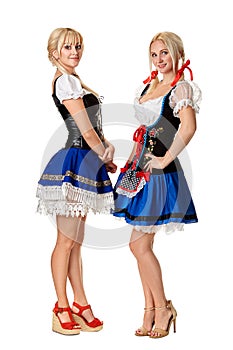 A full length portrait of two beautiful women in a traditional costume isolated on white. Oktoberfest