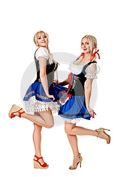 A full length portrait of two beautiful women in a traditional costume isolated on white. Oktoberfest