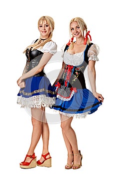 A full length portrait of two beautiful women in a traditional costume isolated on white. Oktoberfest