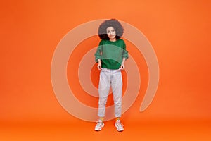 Full length portrait of woman with Afro hairstyle wearing green casual style sweater showing empty