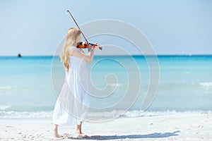 Full length portrait of woman in dress enjoying playing on beach