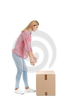 Full length portrait of woman lifting carton box on white background