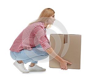 Full length portrait of woman lifting carton box photo