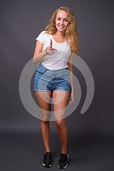 Full length portrait of young beautiful woman with long wavy blond hair