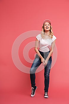 Full length portrait of young blond woman 20s wearing casual jeans and sneakers smiling at camera