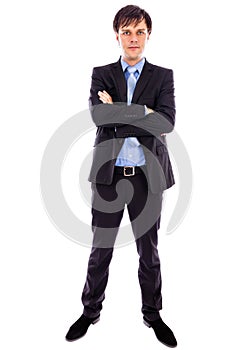 Full length portrait of a young businessman standing with arms f