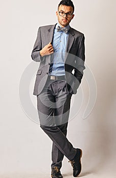 Full length portrait of a young businessman standing with his hands in the pockets.