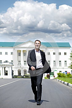 Full length portrait of a young businessman walking down the road