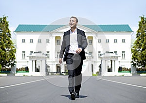 Full length portrait of a young businessman walking down the road