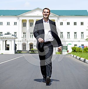Full length portrait of a young businessman walking down the road