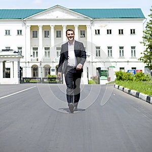 Full length portrait of a young businessman walking down the road