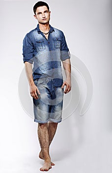 Full Length Portrait of Young Confident Barefoot Man in Blue Jeans