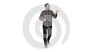 Young confident man in shirt and jeans walking towards camera and pointing to the sides on white background.