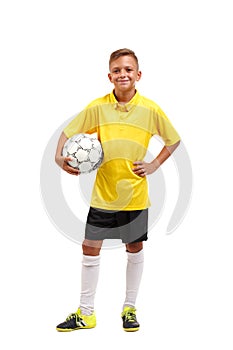 A full-length portrait of a young footballer in a yellow T-shirt holes in arms a ball isolated on a white background.