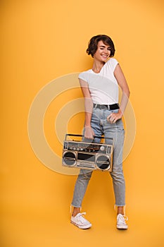 Full length portrait of a young girl holding record player