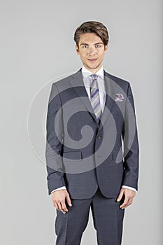 Full length portrait on young handsome man. Elegant businessman in suit isolated on a grey background.