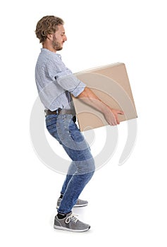 Full length portrait of young man carrying heavy cardboard box on white background