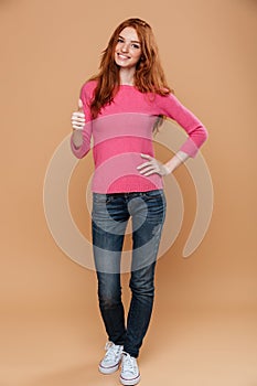 Full length portrait of a young smiling redhead girl