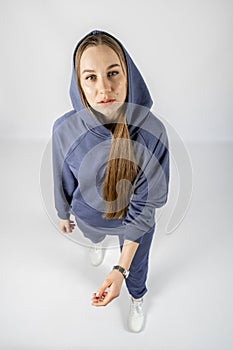 Full length portrait of young sporty fitness women in blue cotton hooded sweatsuit casual outfit. studio shot of blonde