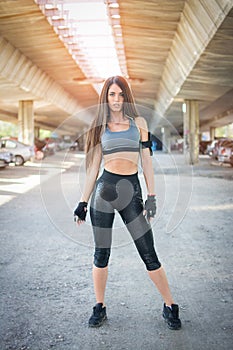 Full length portrait of young sporty woman in sportswear standing outdoors