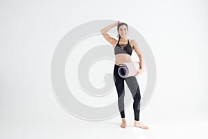 Full length portrait of a young woman holding yoga mat isolated
