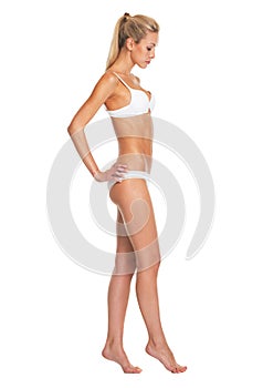 Full length portrait of young woman in lingerie going sideways