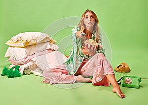 Full length portrait of young woman in pajama turning off TV programme with bad news keeping remote controller holding