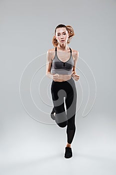 Full length portrait of a young woman in sportswear running