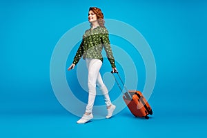 Full length profile photo of charming pretty lady hold rolling suitcase walk airport flight registration wear green