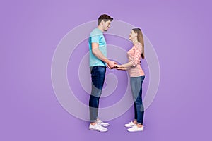 Full length profile photo of cute guy lady couple stand opposite hold hands look eyes love confession wear casual blue