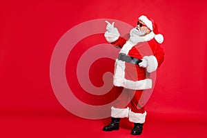 Full length profile side photo of charming santa claus in eyewear eyeglasses showing promo wearing bright costume belt