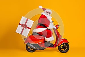 Full length profile side photo of grey white hair bearded santa claus ride drive bike deliver gift box x-mas christmas