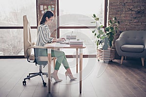 Full length profile side photo of positive smart smm manager girl sit table work laptop have online startup progress aim
