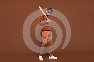Full length profile side photo of young african man serious hold baseball bat  over brown color background