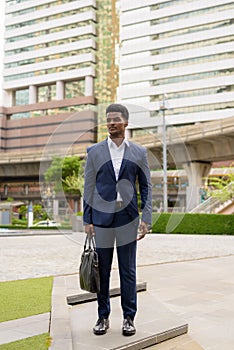 Full length shot of African businessman outdoors in city thinking