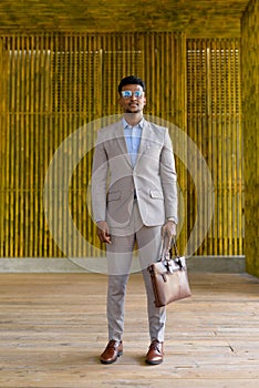 Full length shot of African businessman outdoors wearing eyeglasses