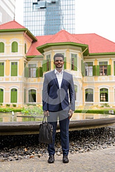 Full length shot of African businessman outdoors wearing suit