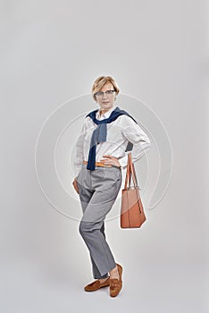 Full length shot of elegant middle aged caucasian woman wearing business attire and glasses looking at camera while