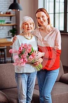 Full-length shot grey-haired dame posing with lady in pinkish blouse