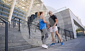 Full length shot of lovely sporty middle aged couple, man and woman in sportswear smiling while talking, standing