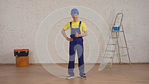 Full length shot of a smiling young construction worker standing in the room under renovation giving a thumbs up.