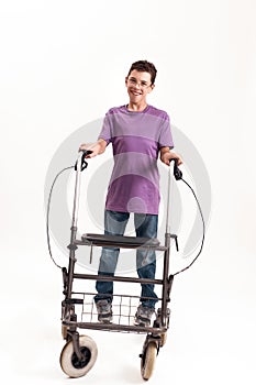 Full length shot of teenaged disabled boy with cerebral palsy in the glasses smiling at camera, taking steps with his