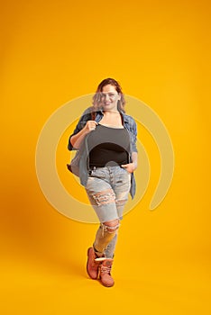 Urban plus-size model posing with backpack and looking at camera
