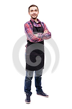 Full length shot of young chef or waiter posing, wearing black apron and shirt isolated on white background